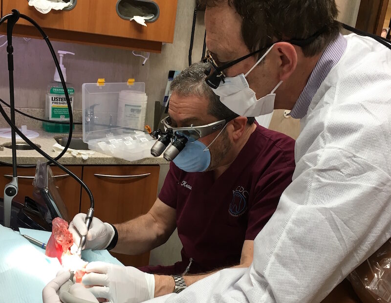 Dentists performing procedure on a patient.